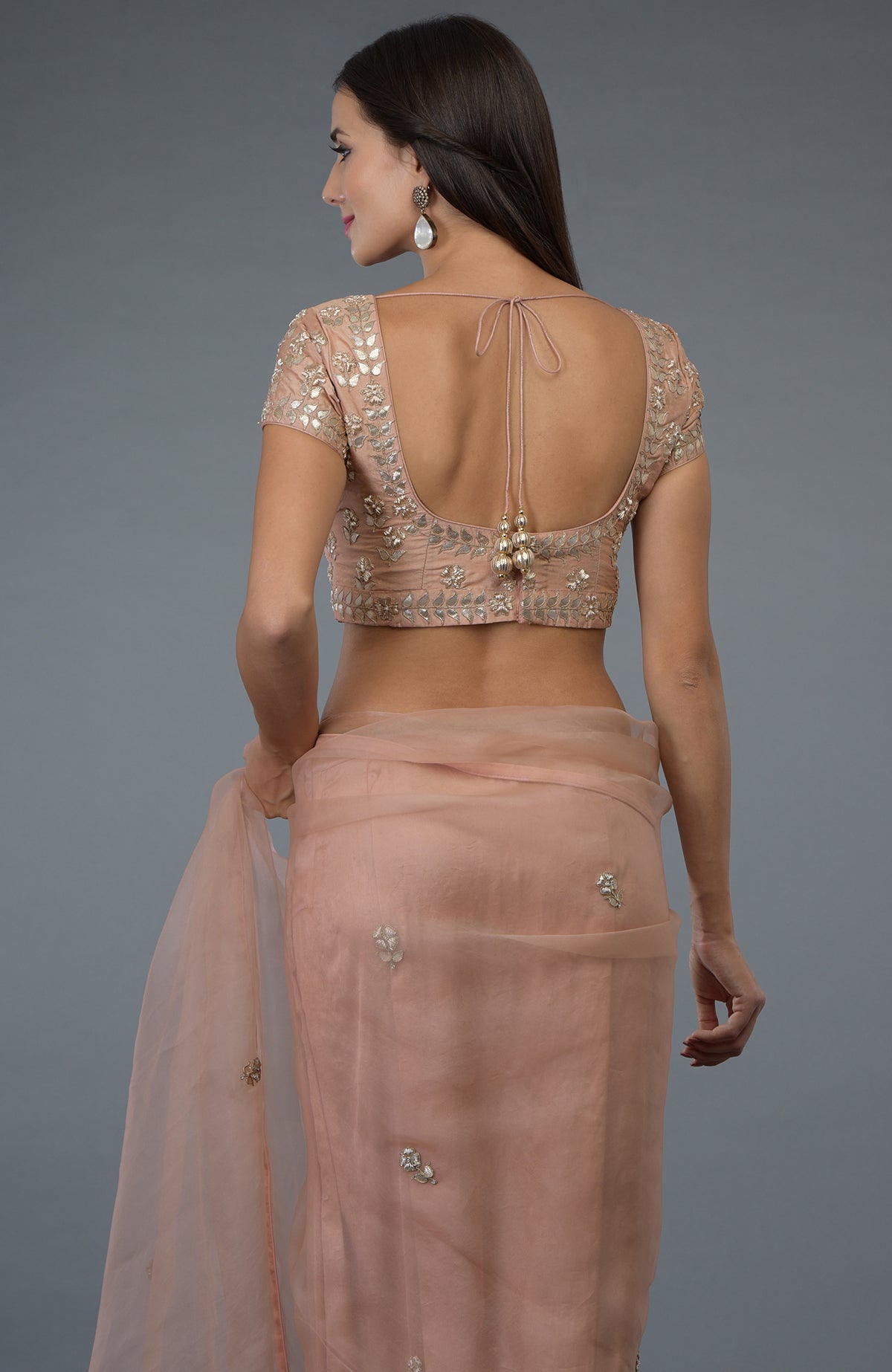 A woman models a pressed rose zardozi gota patti embroidered saree and blouse.
