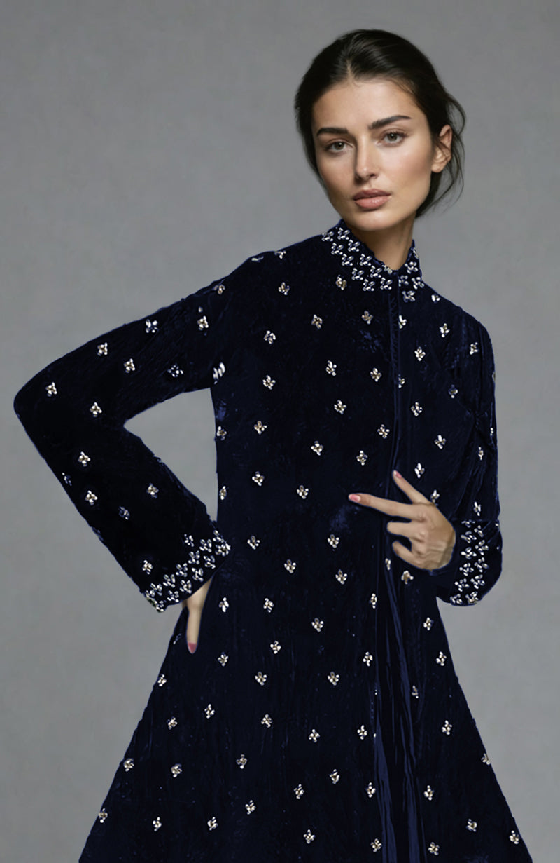A woman models a midnight blue velvet jacket with silver crystal embroidery.