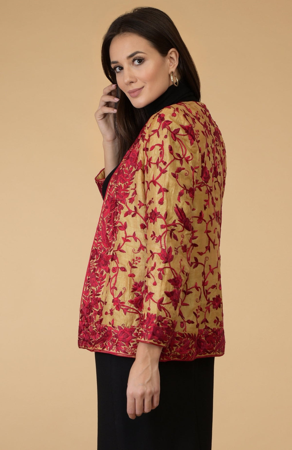 A woman models a fawn gold Parsi Gara embroidered tussar silk shrug jacket.