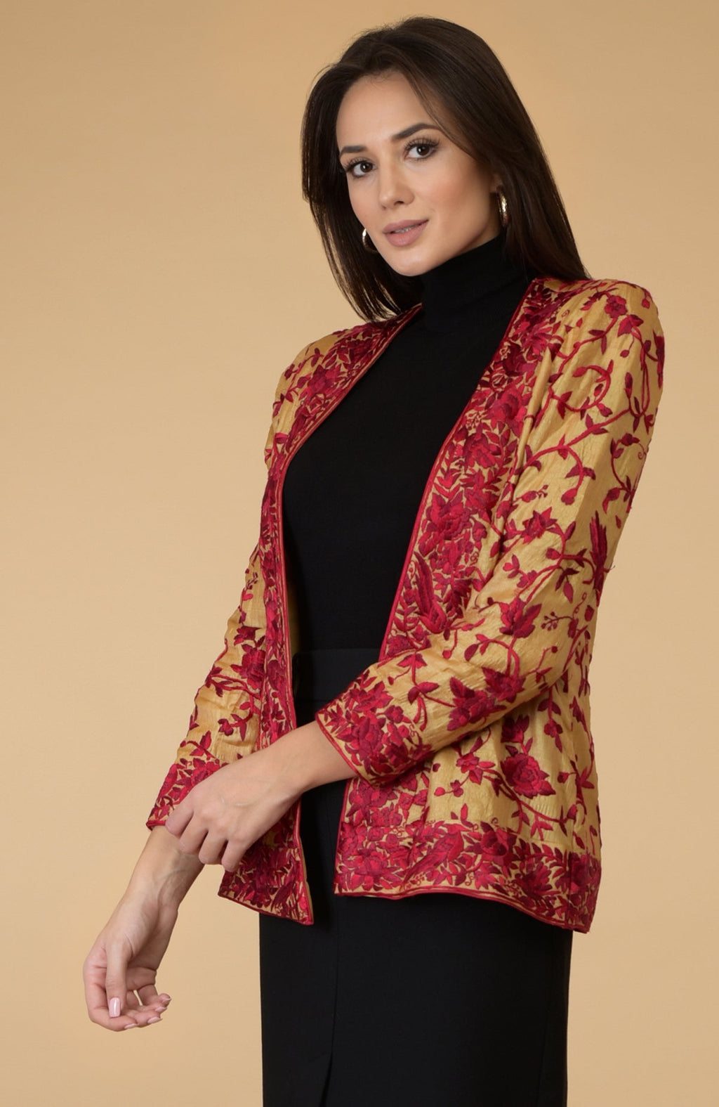 A woman models a fawn gold Parsi Gara embroidered tussar silk shrug jacket.