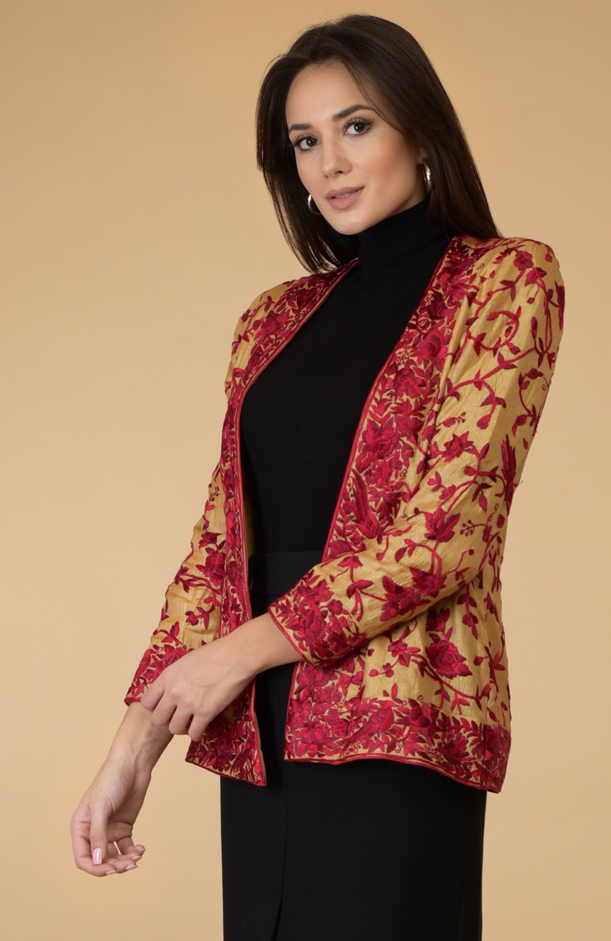 A woman models a fawn gold Parsi Gara embroidered tussar silk shrug jacket.
