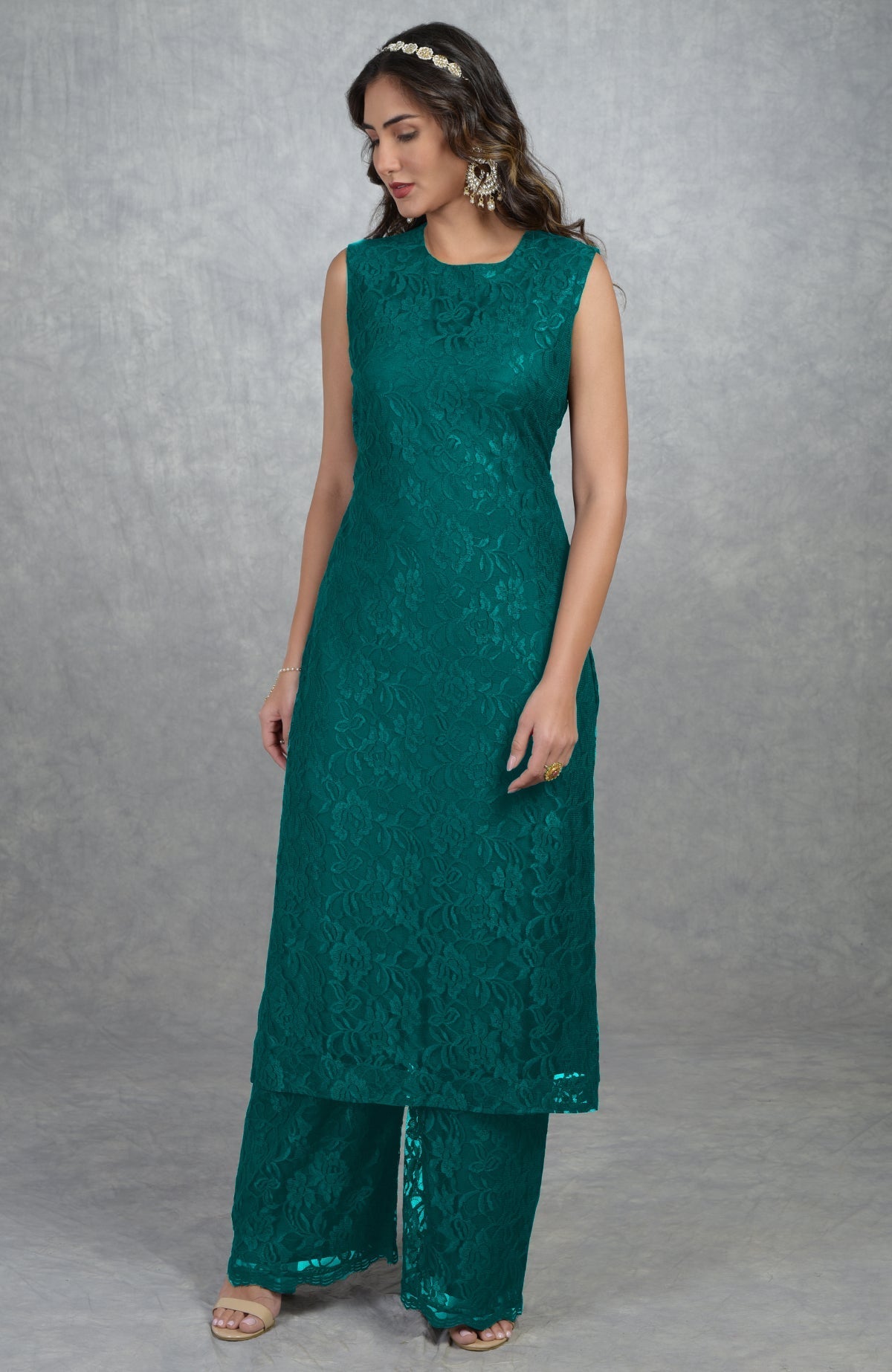 A woman models a sleeveless green lace tunic kurta and wide-leg pants.