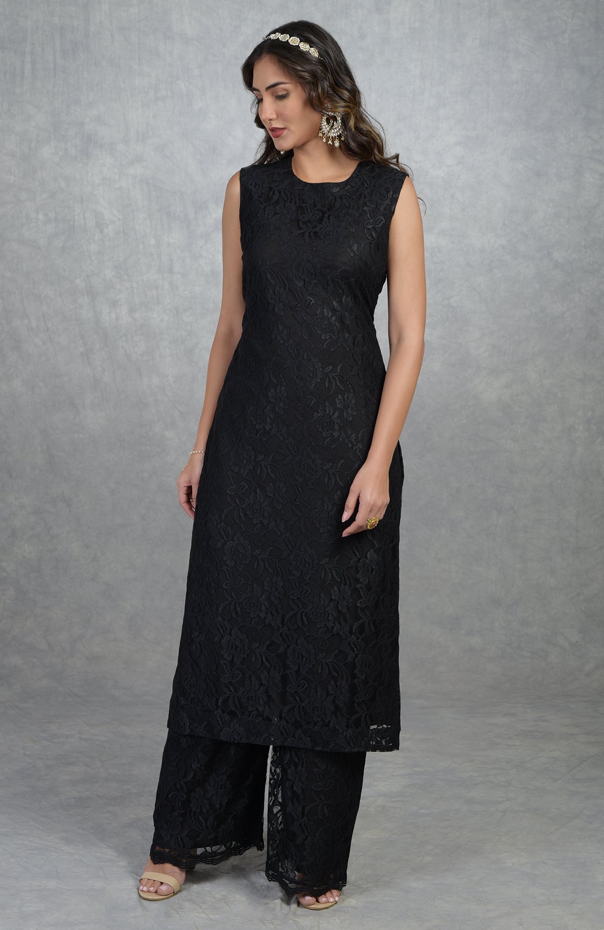 A woman models a black fine lace tunic kurta with wide-leg pants.