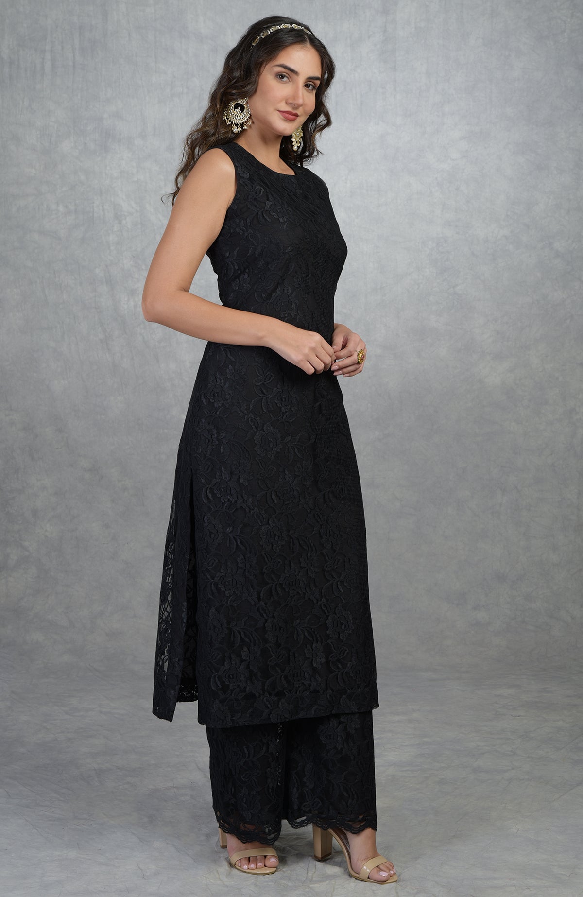 A woman models a black fine lace tunic kurta with wide-leg pants.