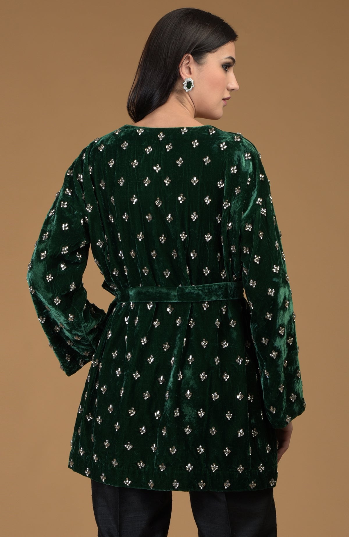 Emerald green silk velvet jacket with crystal hand embroidery and a waist belt.
