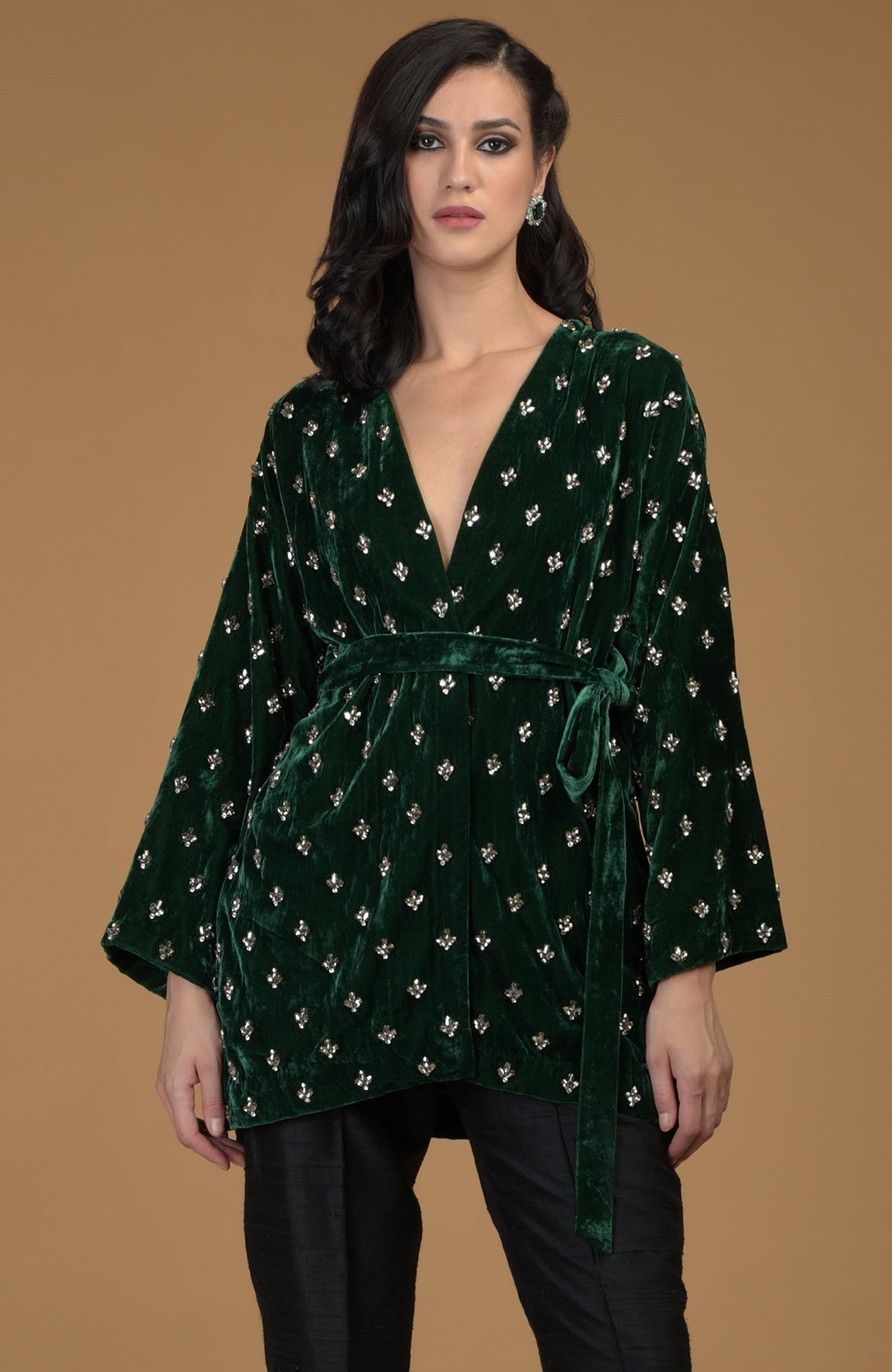 Emerald green silk velvet jacket with crystal hand embroidery and a waist belt.