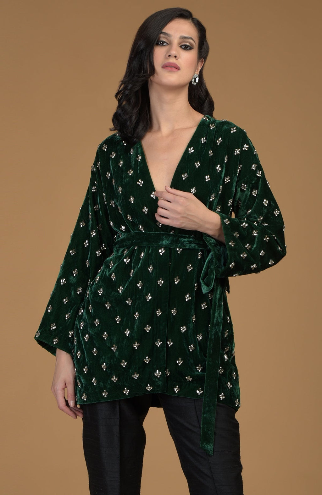 Emerald green silk velvet jacket with crystal hand embroidery and a waist belt.