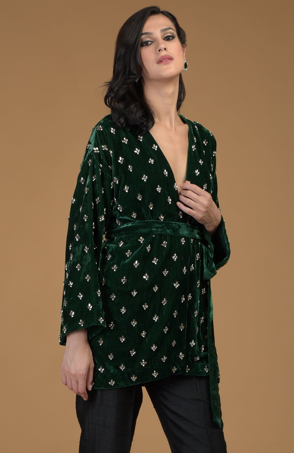 Emerald green silk velvet jacket with crystal hand embroidery, worn by a woman.