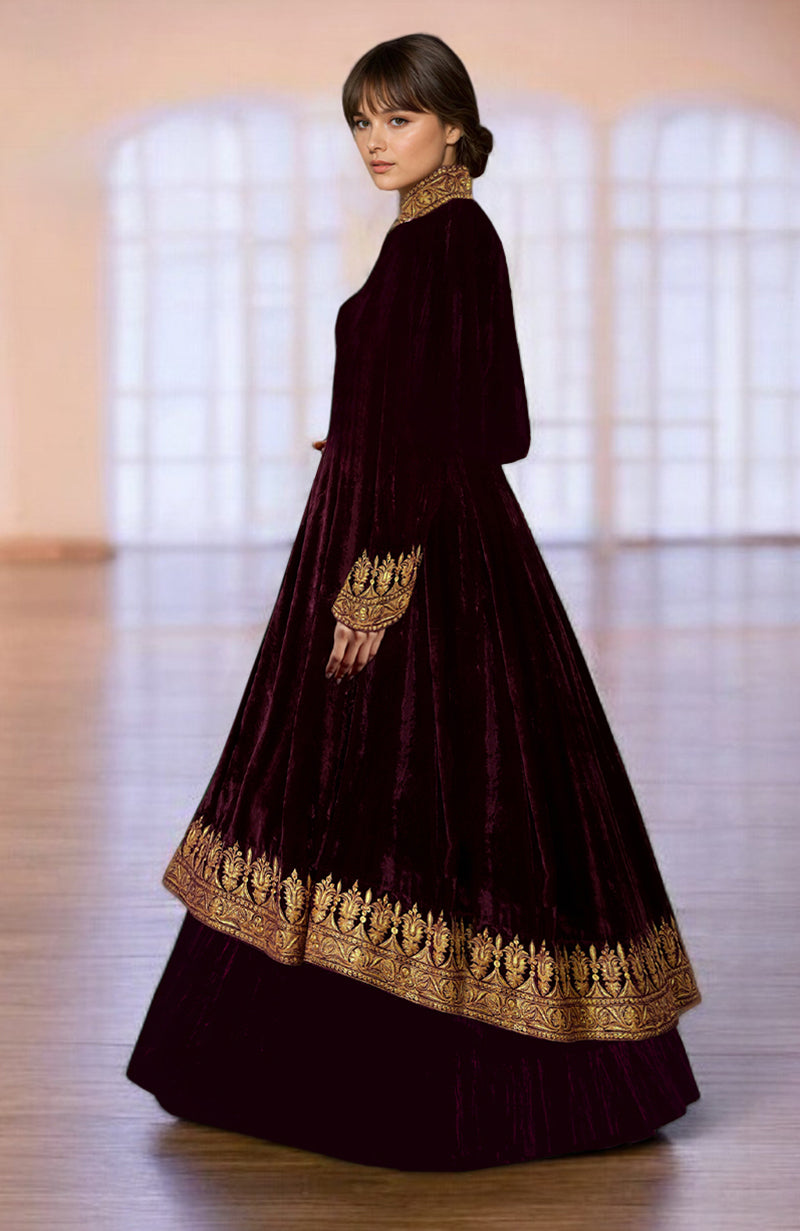 A woman models a maroon velvet jacket with gold embroidery over a matching skirt.