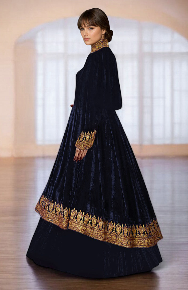 A woman models a midnight blue velvet jacket with gold embroidery and a tiered skirt.