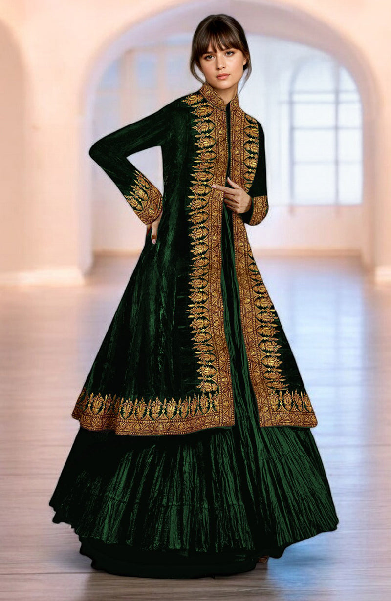 A woman models an emerald green velvet jacket with gold embroidery and a crushed silk tiered skirt.
