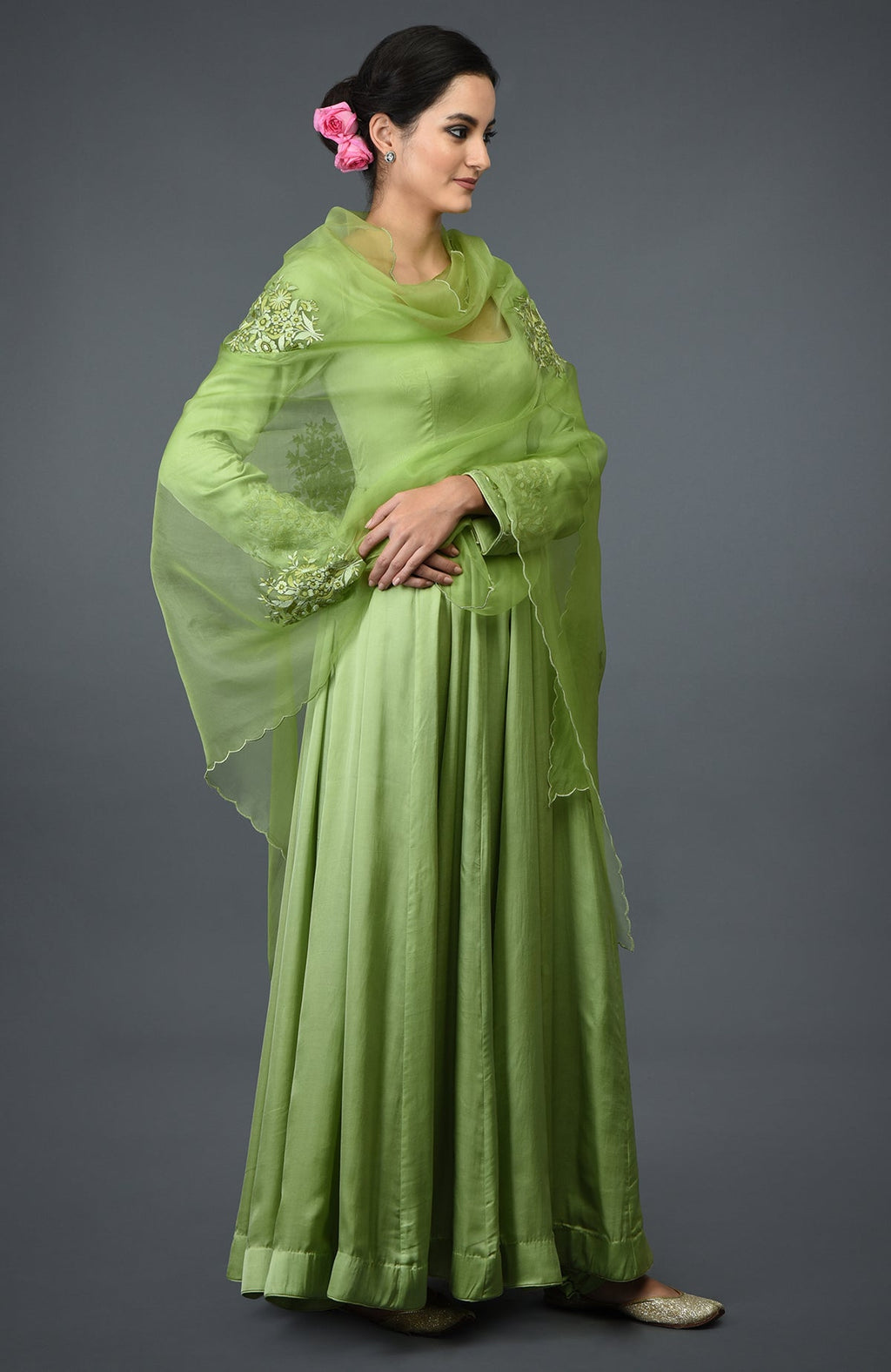 A woman models a pista green floral embroidered anarkali suit with a dupatta.