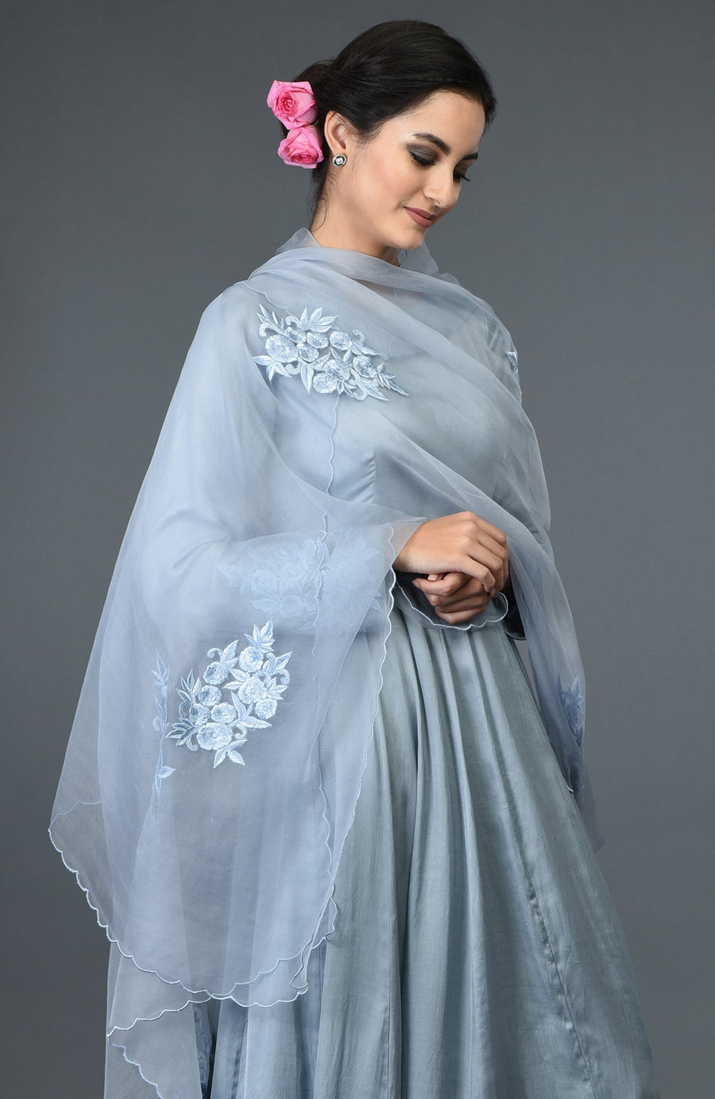 A woman models a powder blue floral embroidered anarkali suit with a matching dupatta.