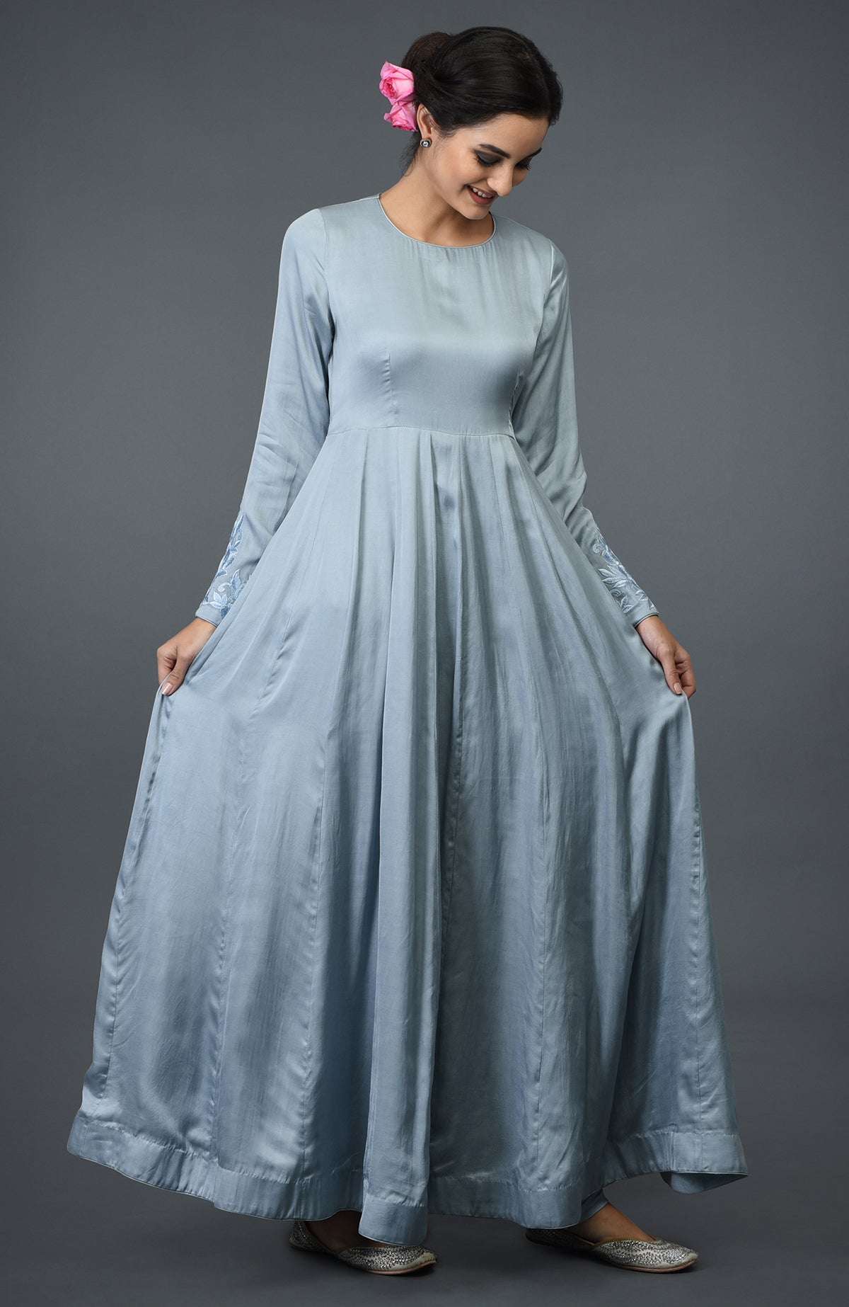 A woman in a powder blue floral embroidered anarkali suit with a dupatta.