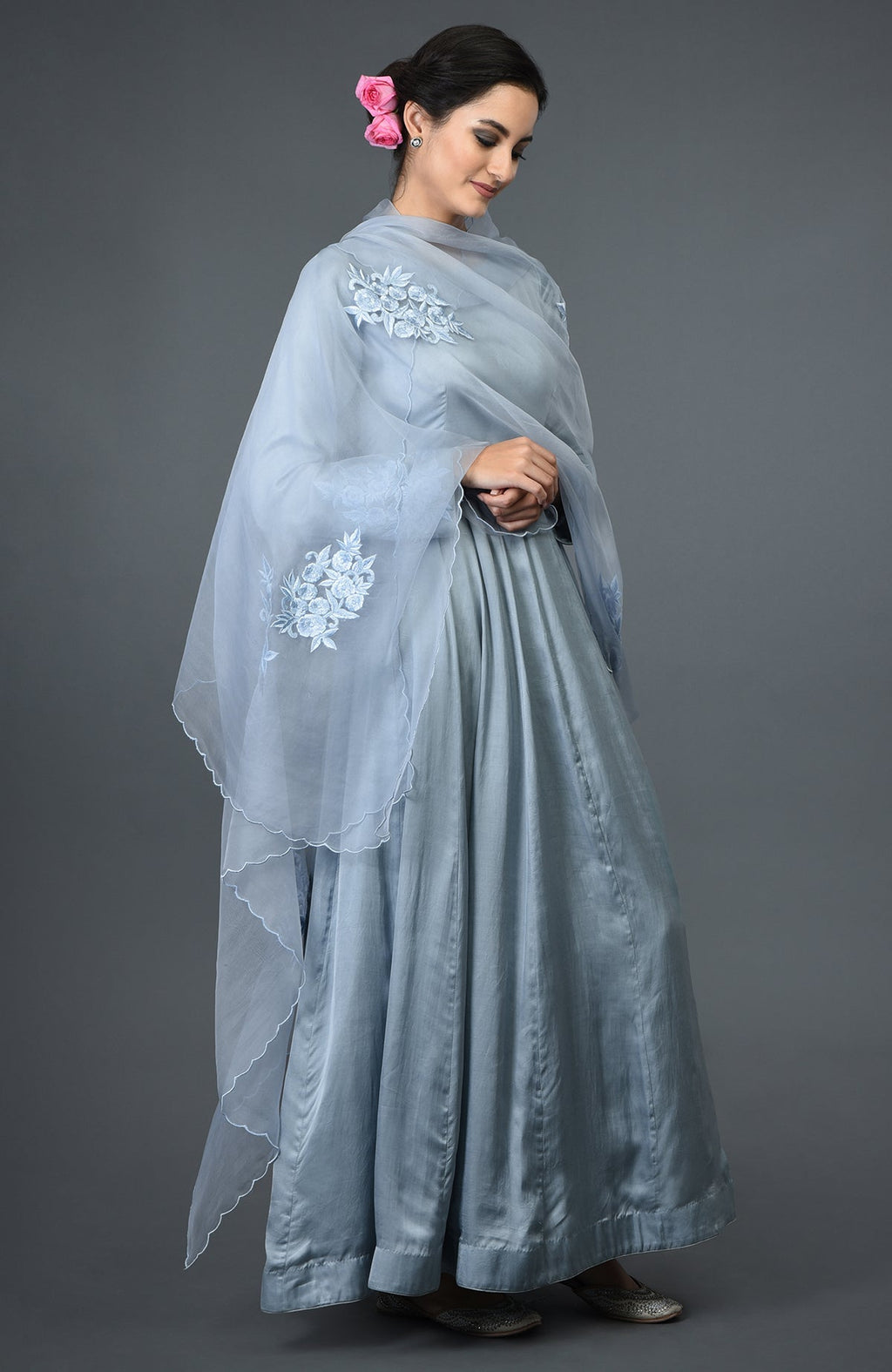 A woman models a powder blue floral embroidered Anarkali suit with a matching dupatta.