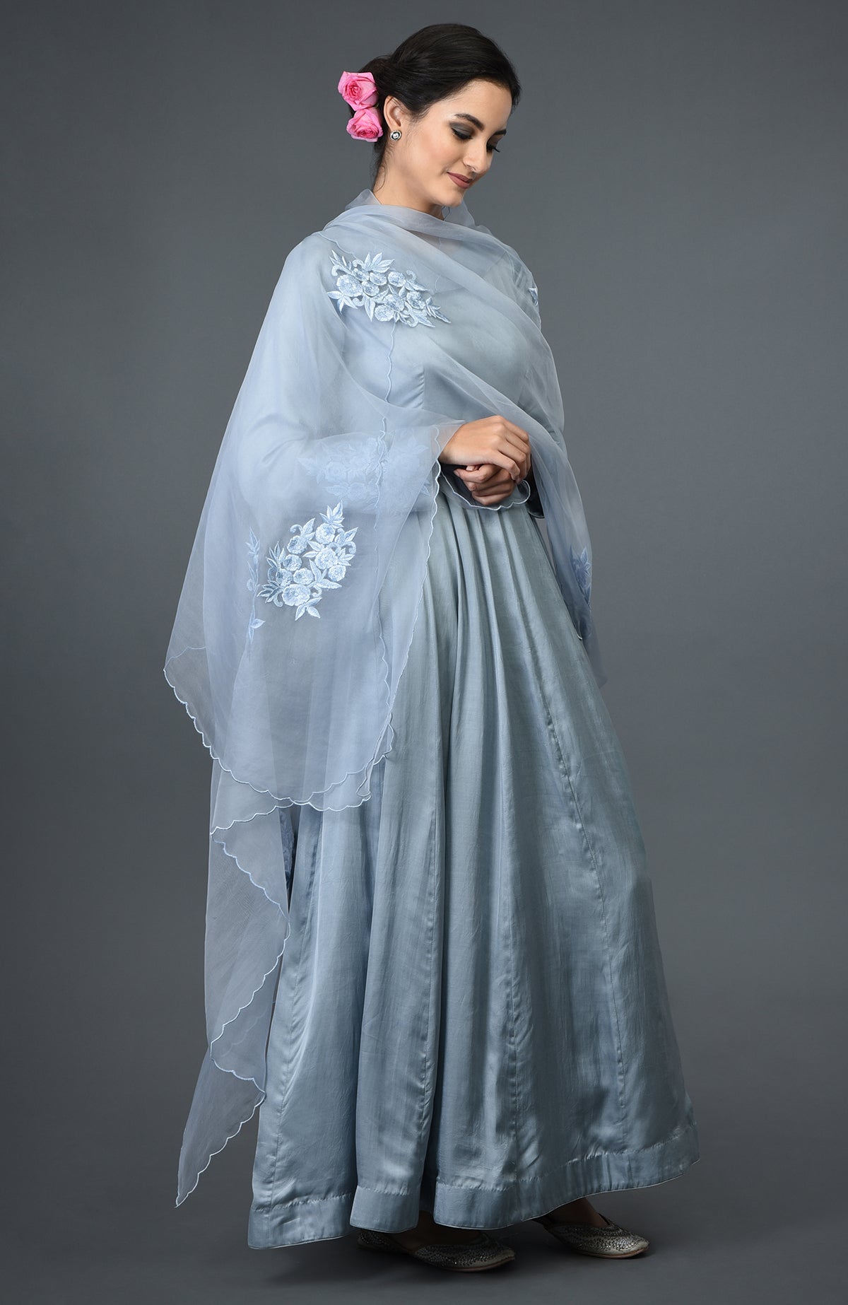 A woman models a powder blue floral embroidered Anarkali suit with a matching dupatta.