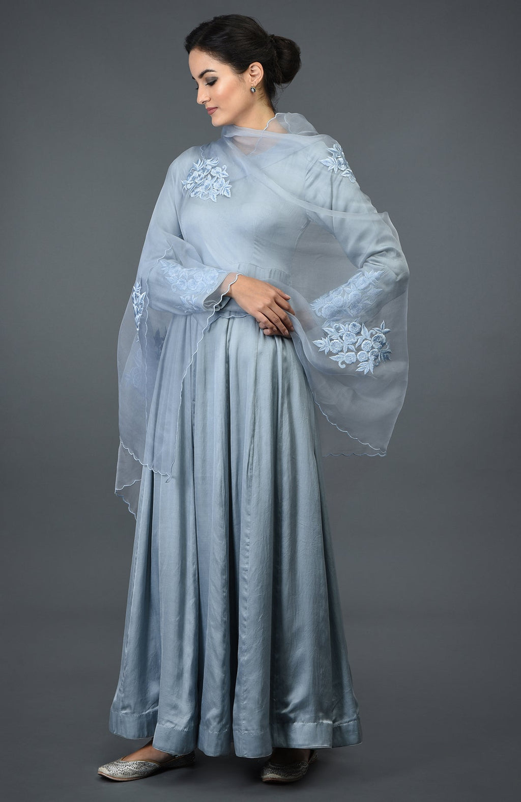 A woman models a powder blue floral embroidered anarkali suit with a dupatta.