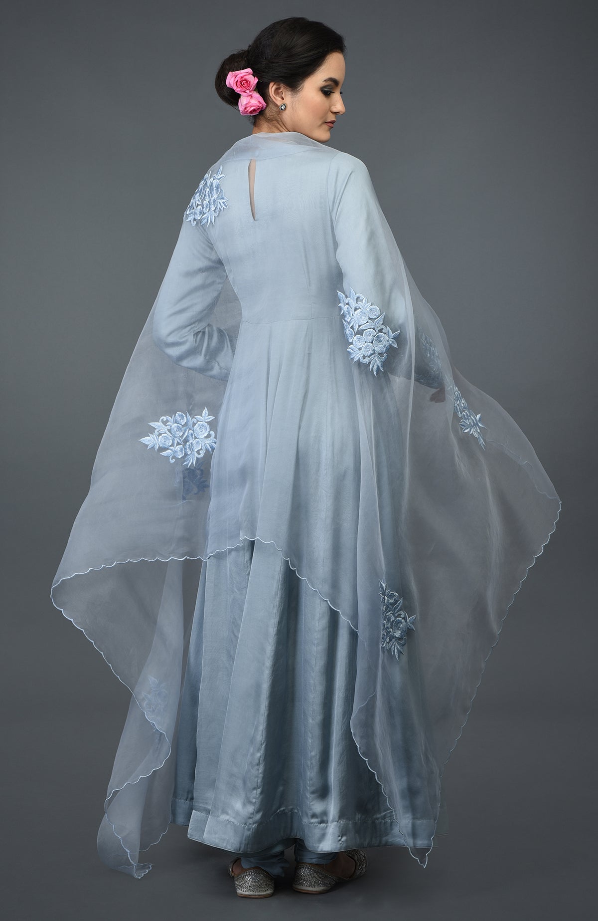 A woman models a powder blue floral embroidered anarkali suit with a dupatta.