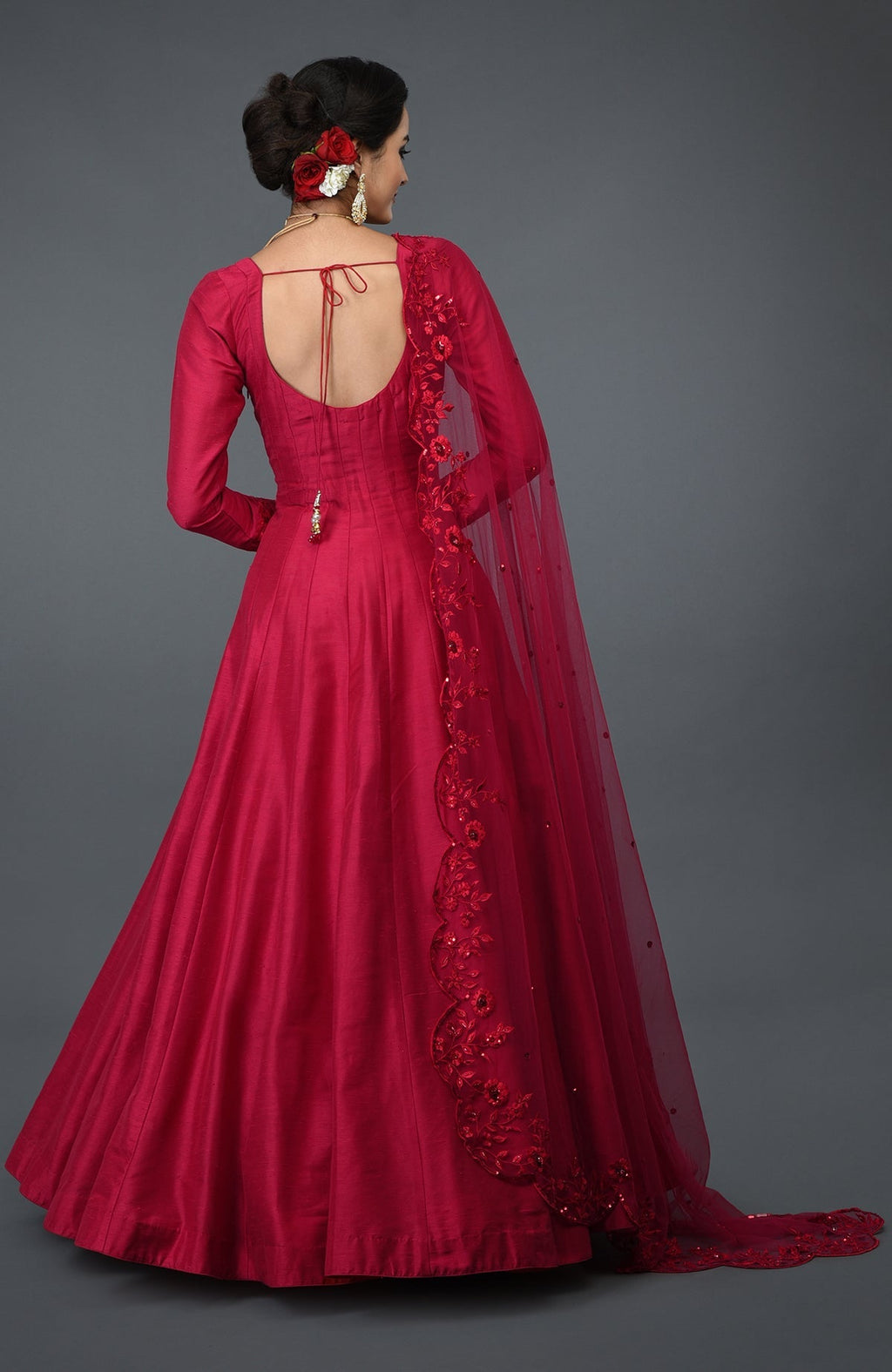 A woman in a red anarkali gown with a floral embroidered dupatta.