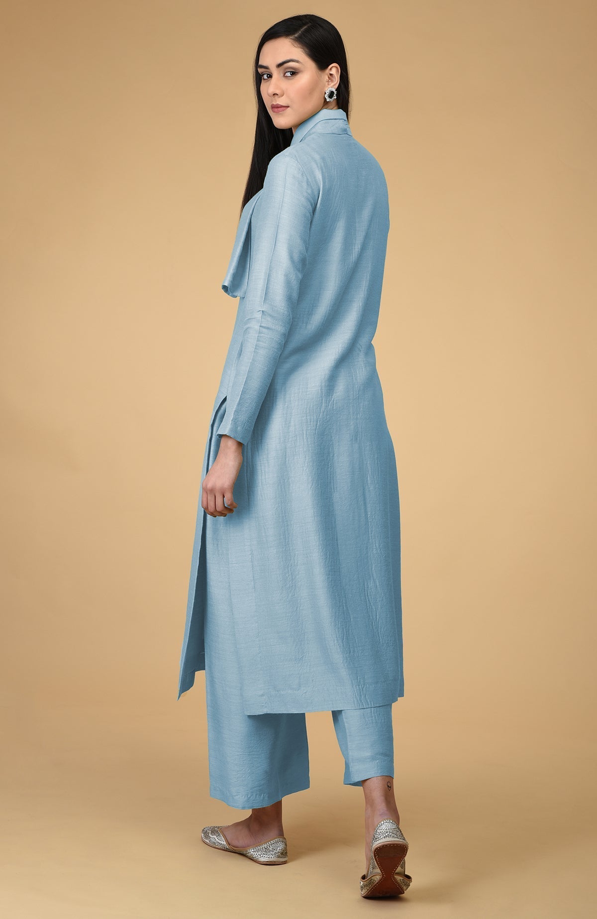 A woman models a winter sky blue tie-neck kurta set with wide-leg pants.