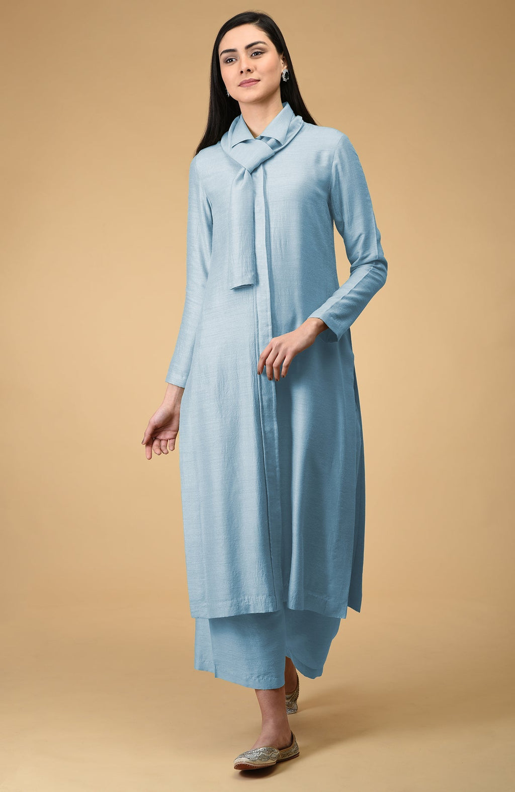 A woman models a light blue tie-neck kurta and wide-leg pants set.