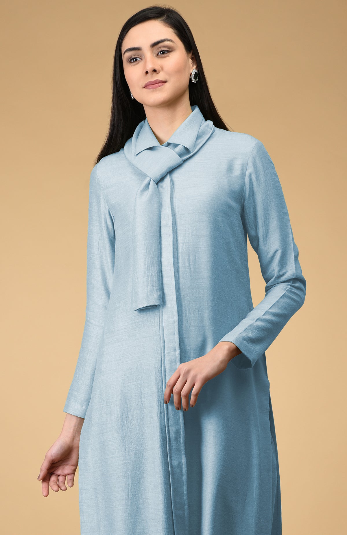 A woman models a light blue tie-neck kurta with long sleeves.