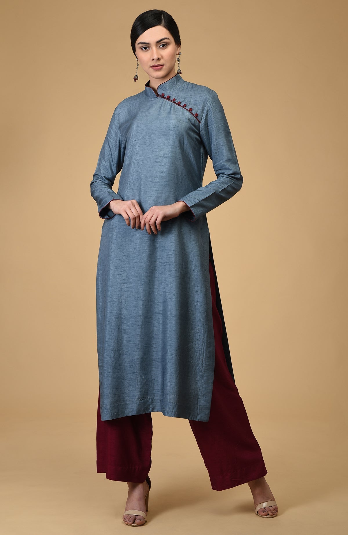 A woman models a blue-grey mandarin collared kurta with maroon wide-leg pants.