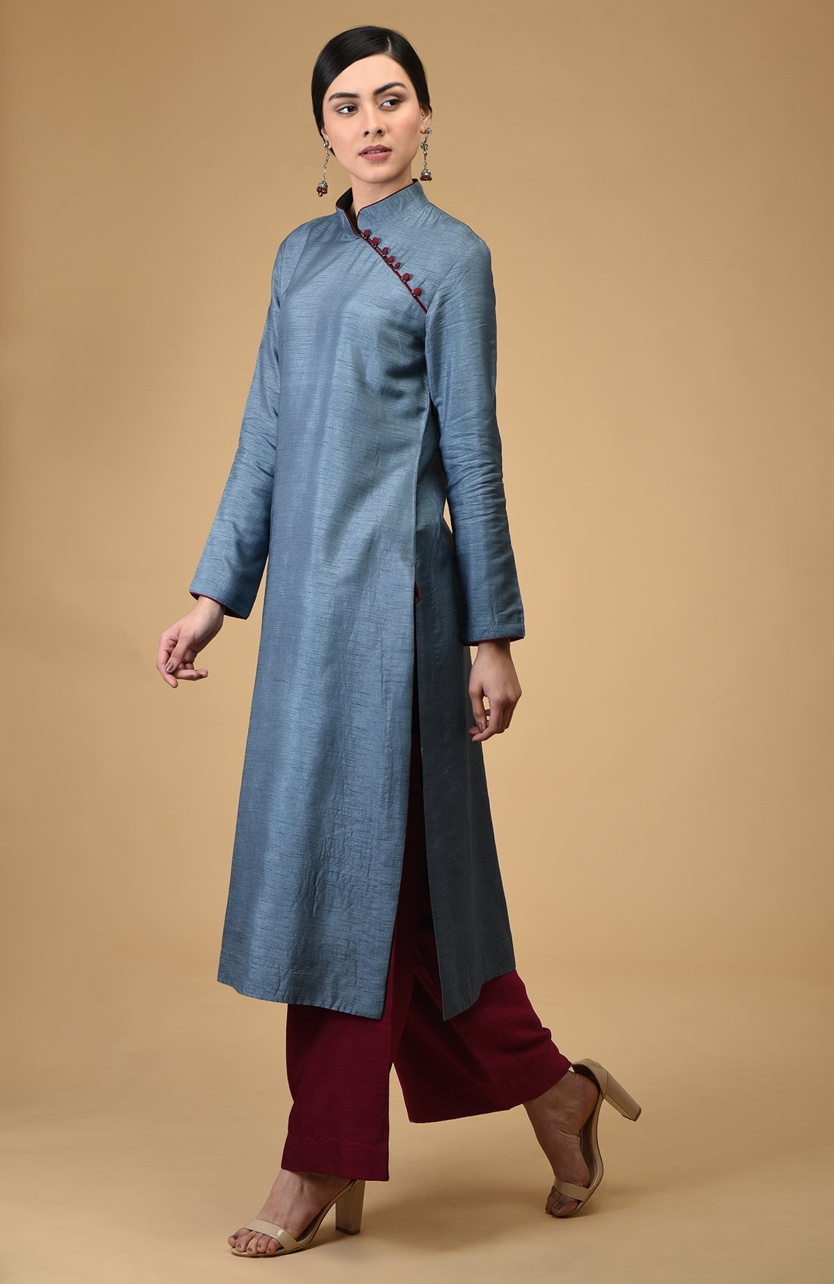 A woman models a blue-grey mandarin collared kurta with maroon wide-leg pants.