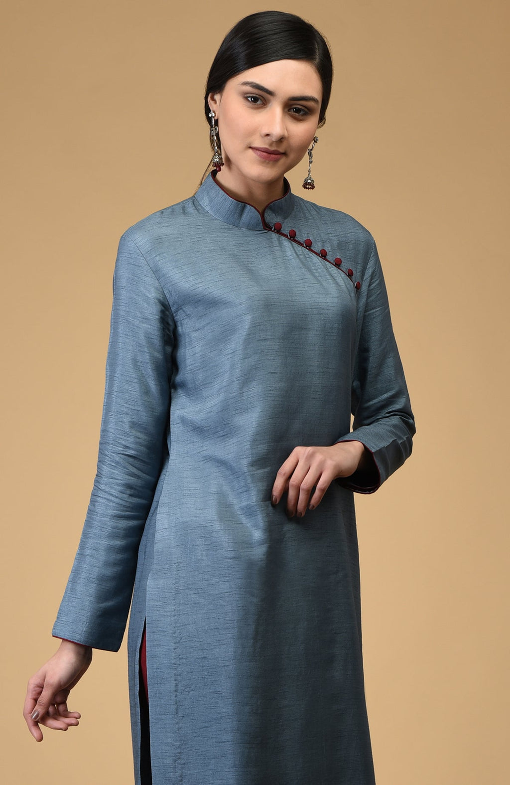 A woman models a blue-grey mandarin collared kurta with maroon buttons and trim.