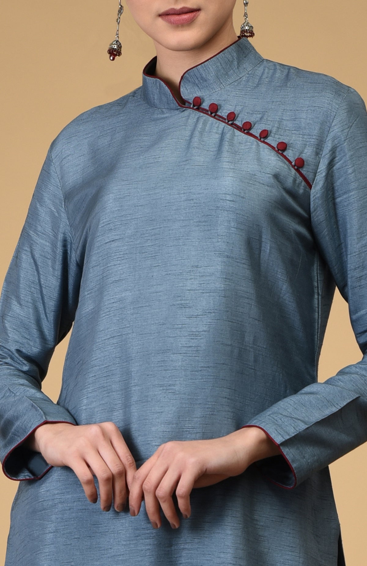 A woman models a blue-grey kurta with a maroon mandarin collar and button placket.