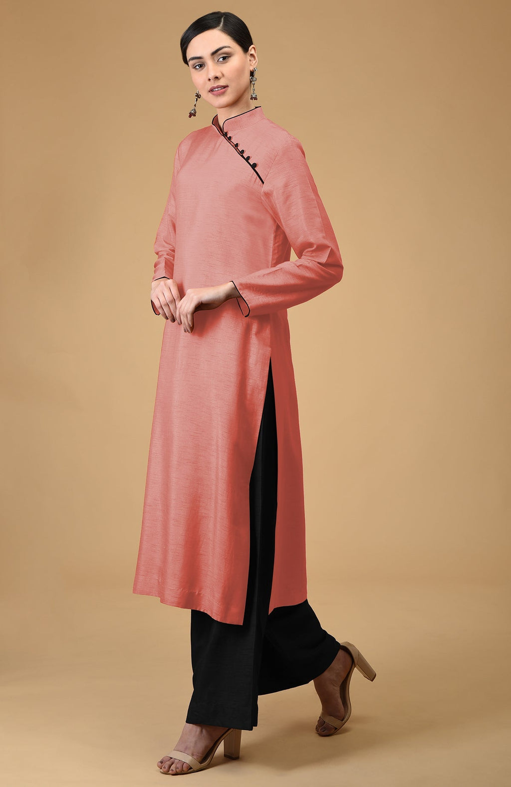 A woman models a terracotta mandarin collared kurta with black wide-leg pants.