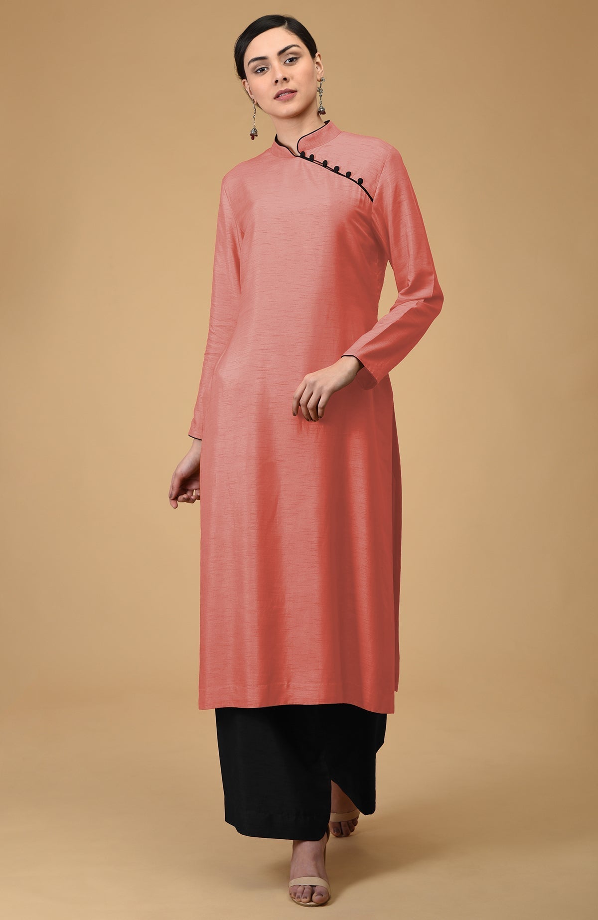 A woman models a terracotta mandarin collared kurta with black wide-leg pants.