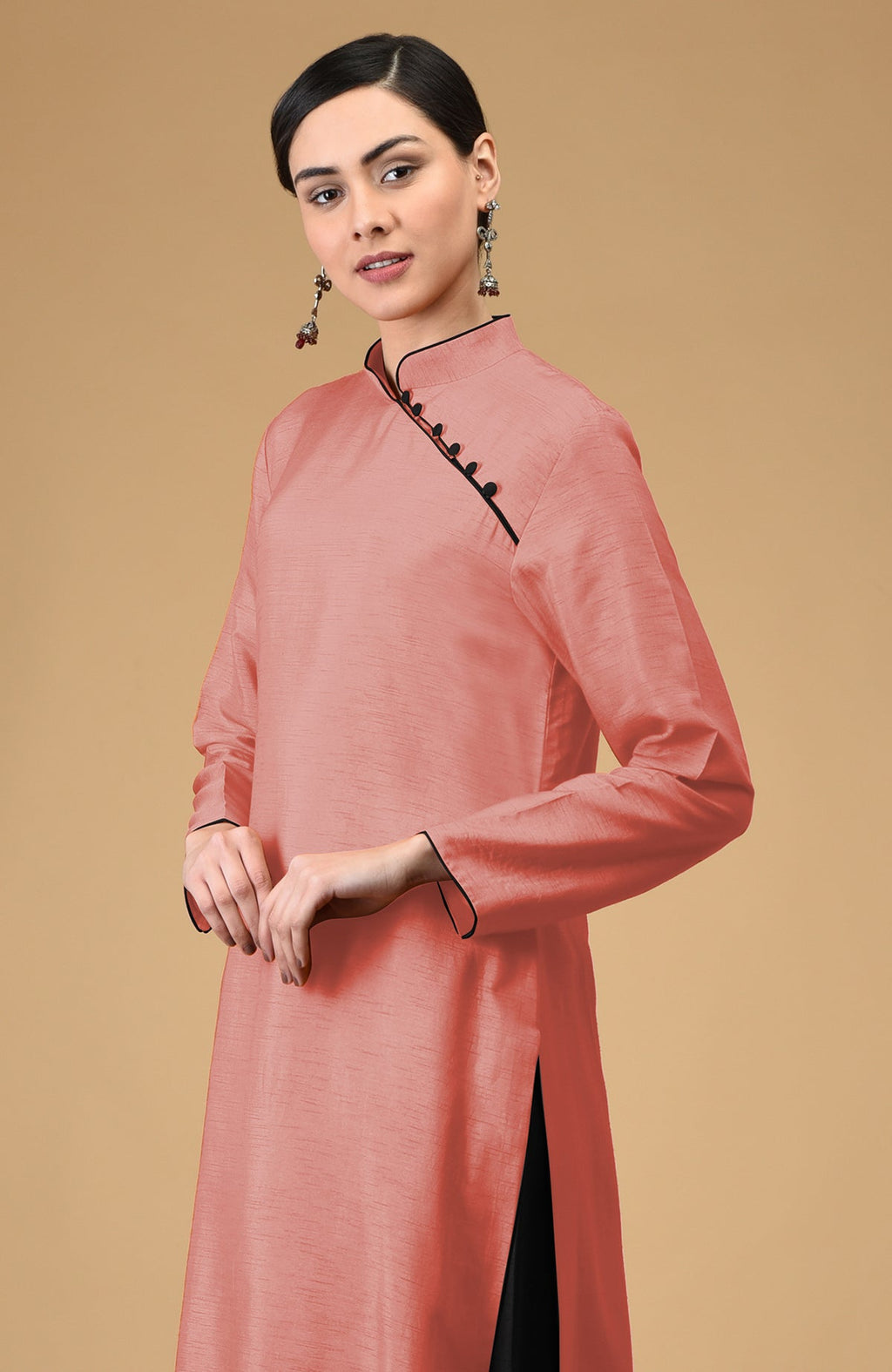 A woman models a terracotta-black mandarin collared kurta set with black buttons.