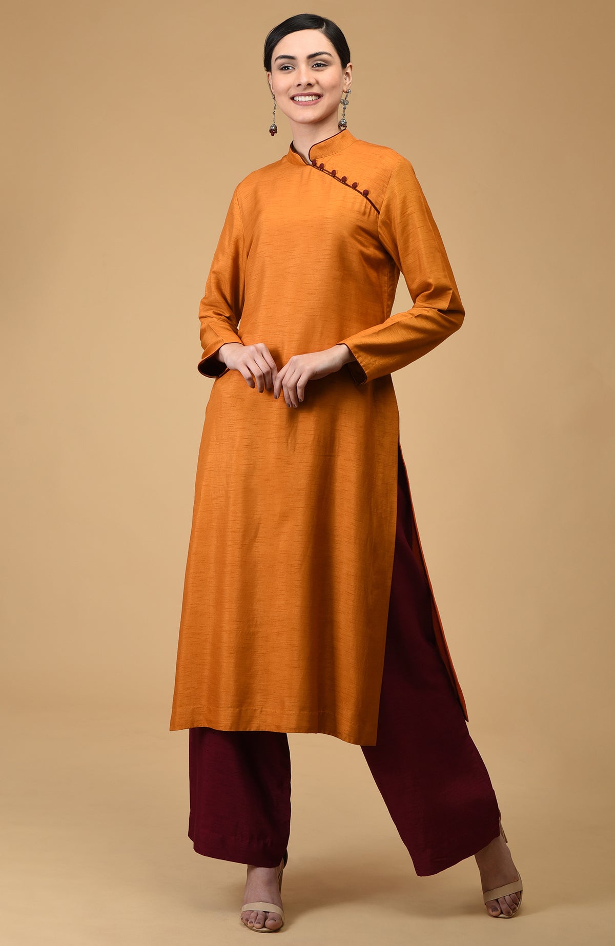 A woman models a mustard mandarin collared kurta with maroon wide-leg pants.