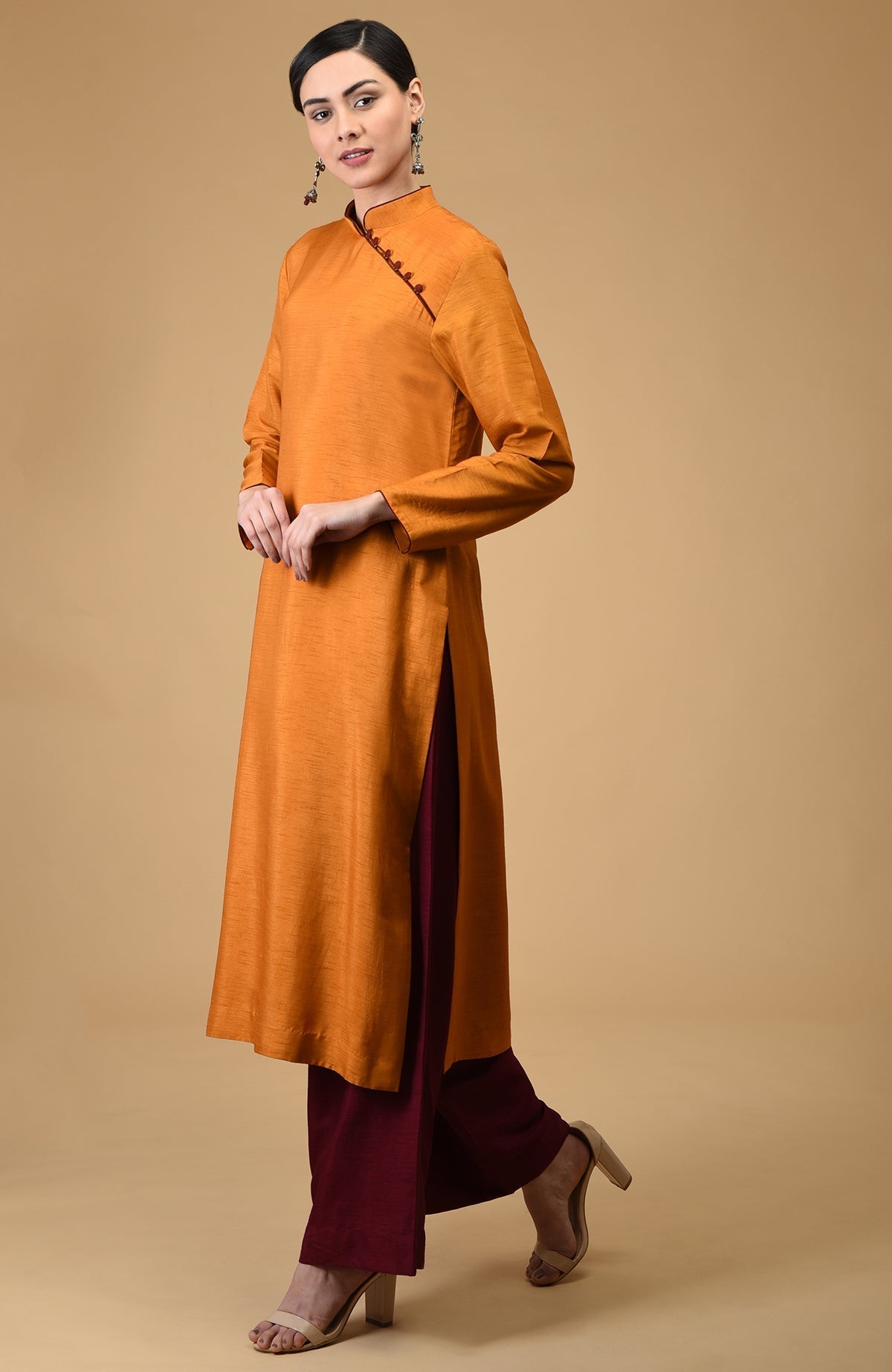 A woman models a mustard mandarin collared kurta with maroon wide-leg pants.
