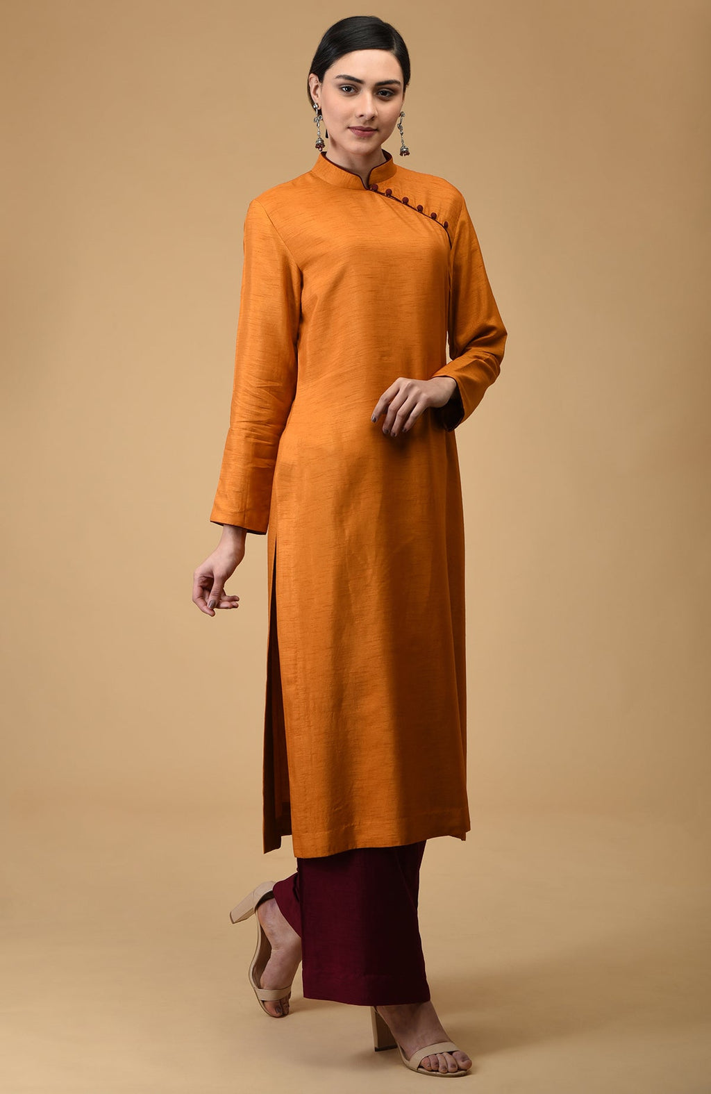 A woman models a mustard mandarin collared kurta with maroon wide-leg pants.