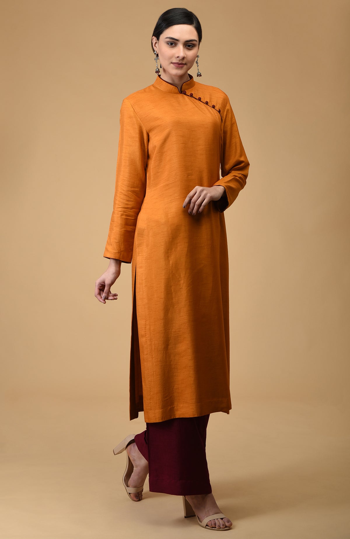 A woman models a mustard mandarin collared kurta with maroon wide-leg pants.