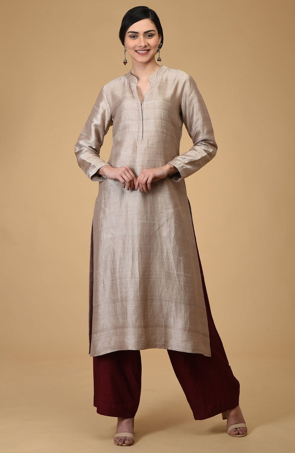 A woman models a beige raw silk kurta with maroon wide-leg pants.