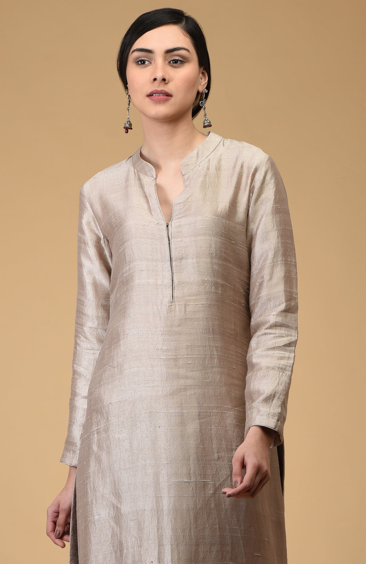 A woman models a beige pure raw silk kurta with a mandarin collar and front zipper.