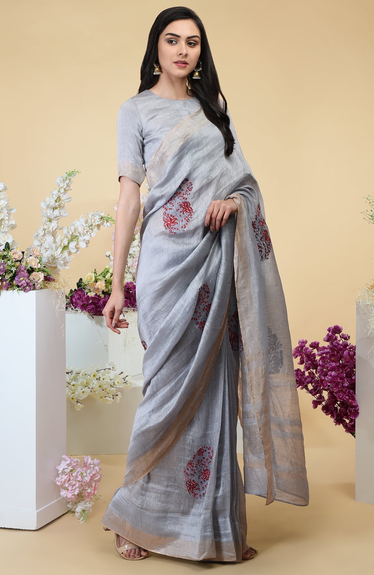 Dove grey linen saree with red paisley embroidery and gold zari borders.