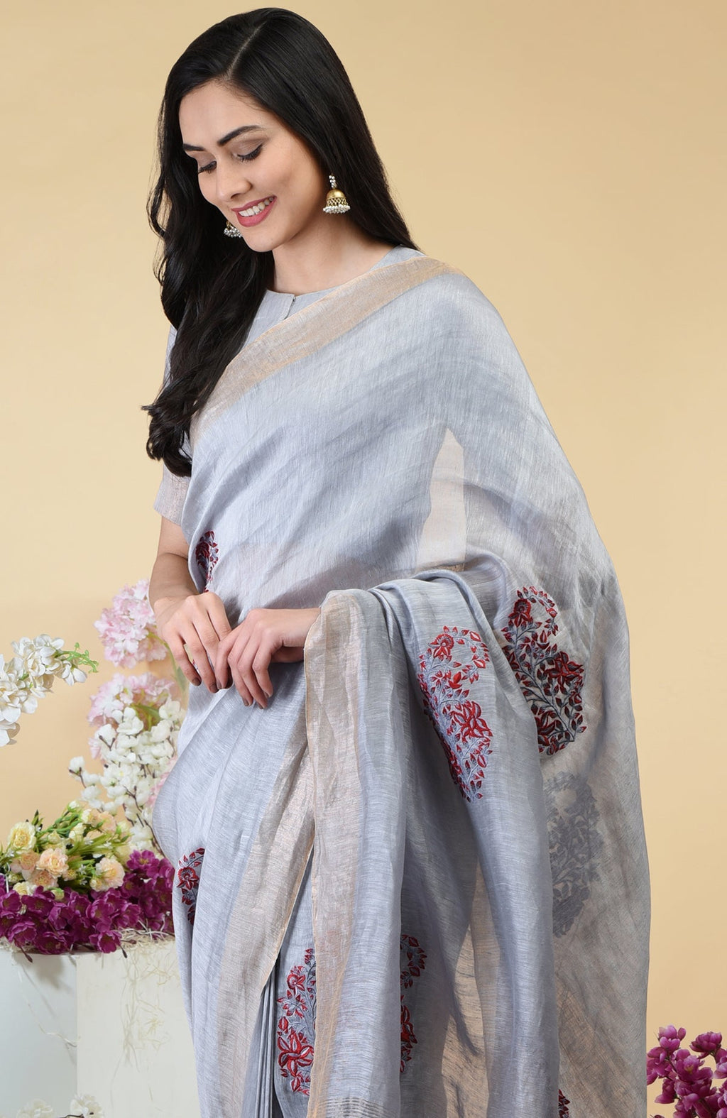Dove grey linen saree with red paisley embroidery and gold zari borders.