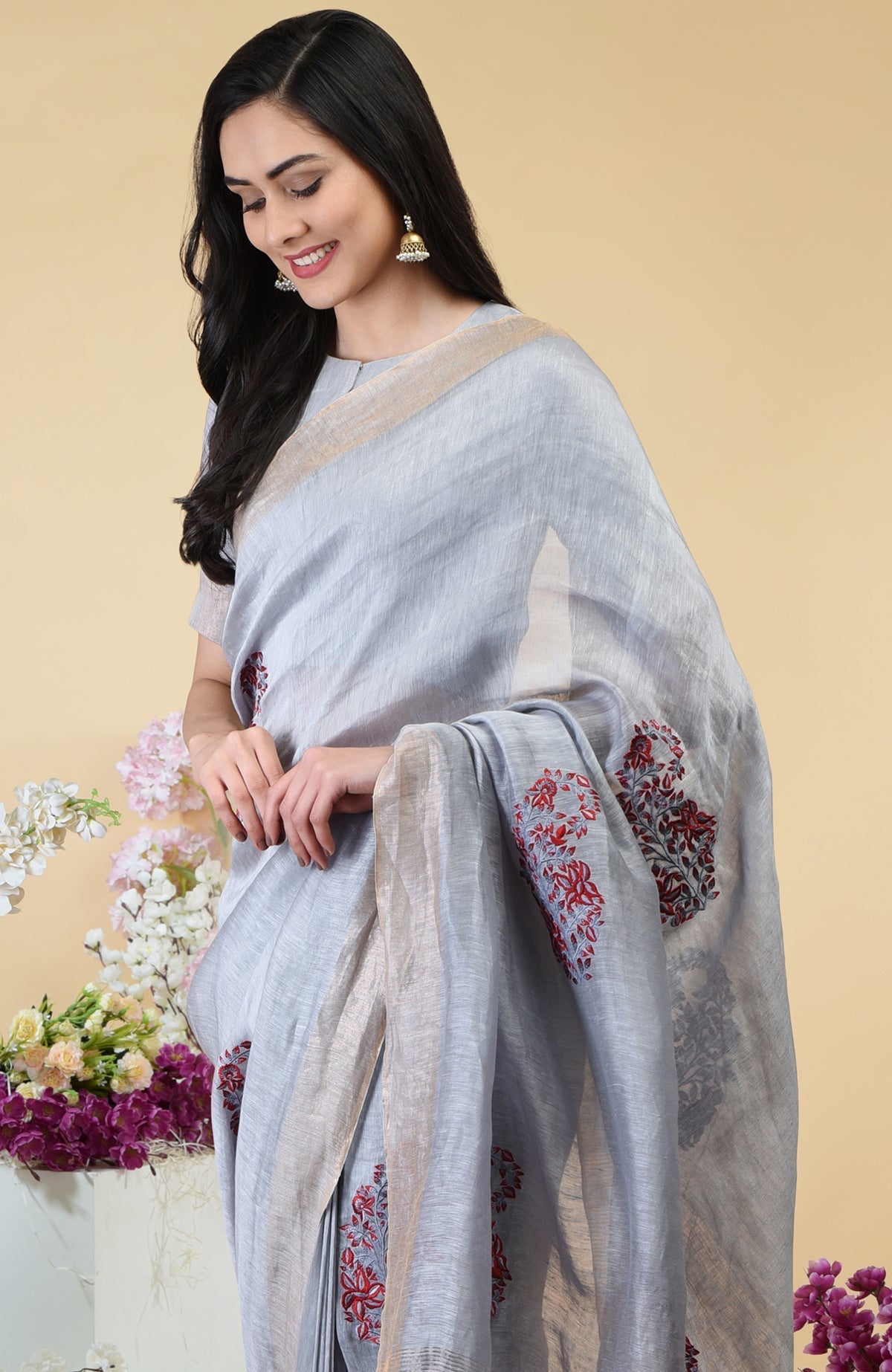 Dove grey linen saree with red paisley embroidery and gold zari borders.