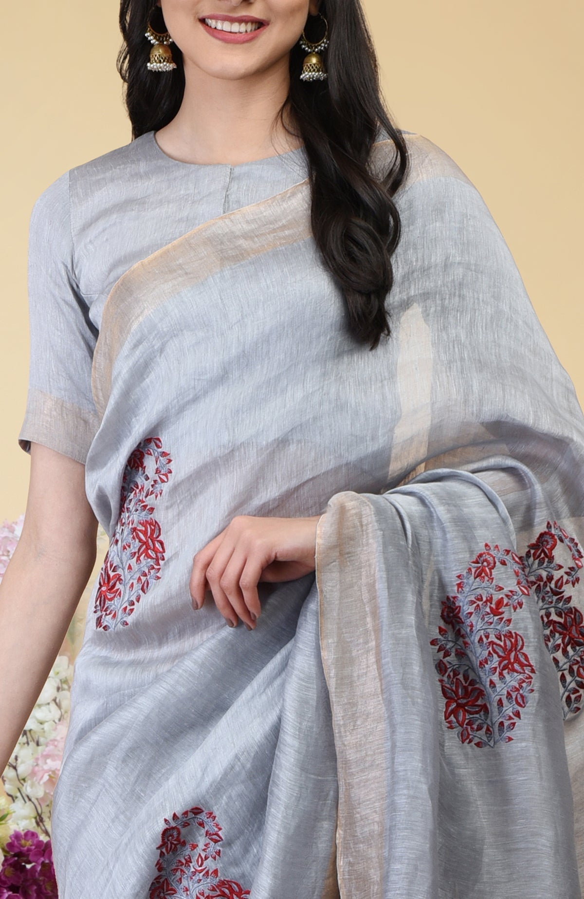 Dove grey linen saree with red paisley embroidery and gold zari borders.