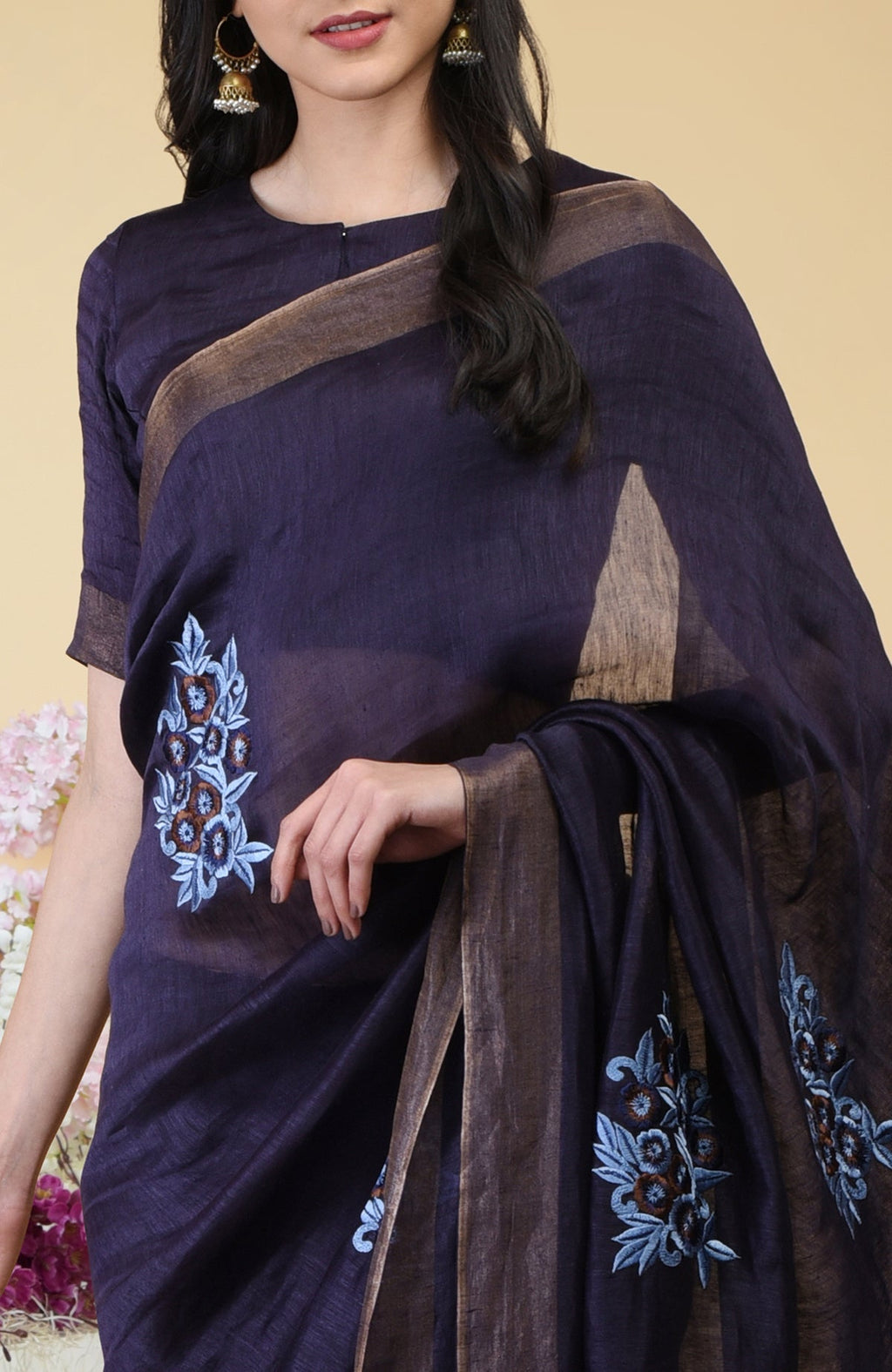 Eclipse blue linen saree with floral embroidery and gold zari borders.