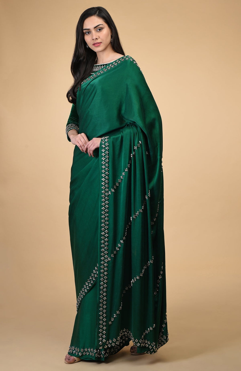 Woman in an emerald green crystal hand-embroidered blouse and matching saree.