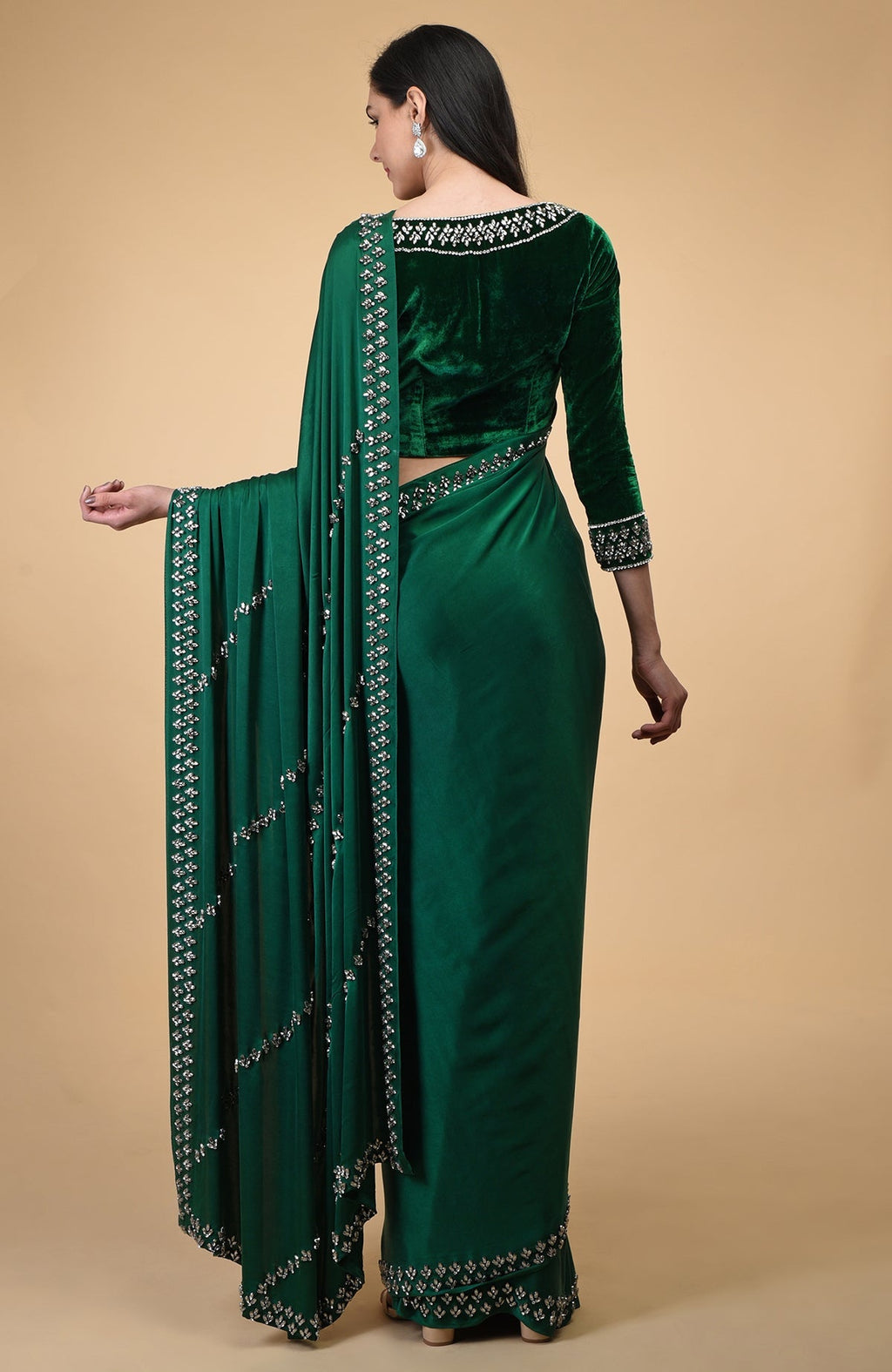 Woman in an emerald green crystal hand-embroidered blouse and matching saree.