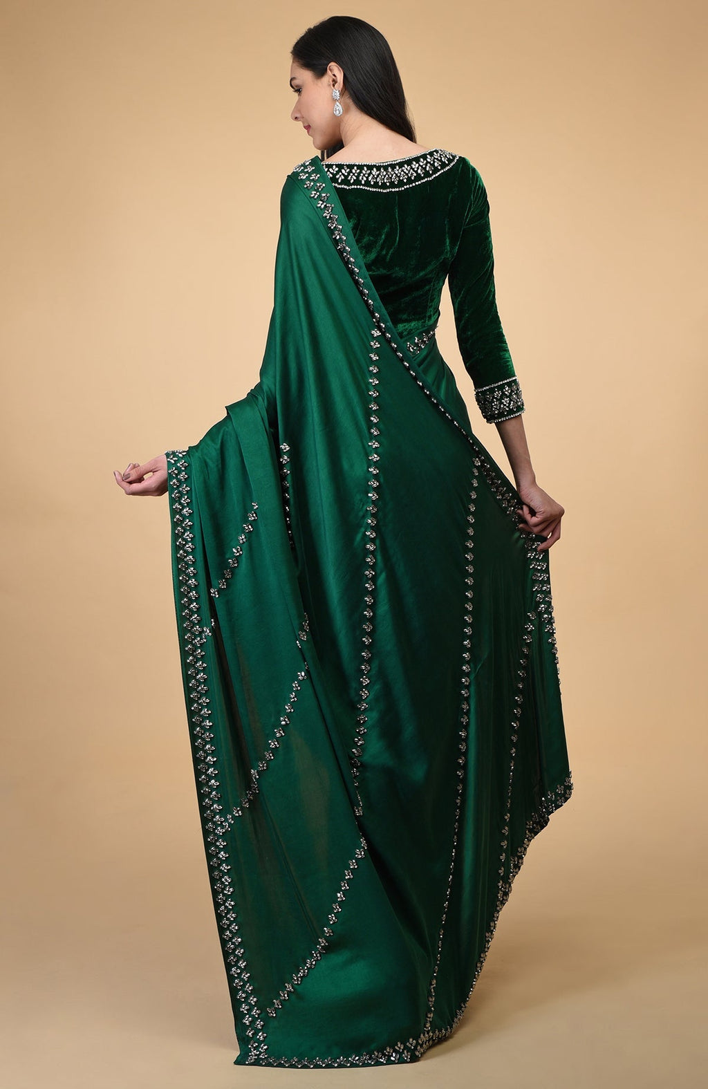 Woman in an emerald green crystal hand-embroidered blouse and matching draped fabric.