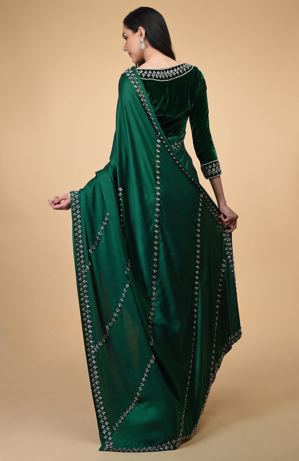 Woman in an emerald green crystal hand-embroidered blouse and matching draped fabric.