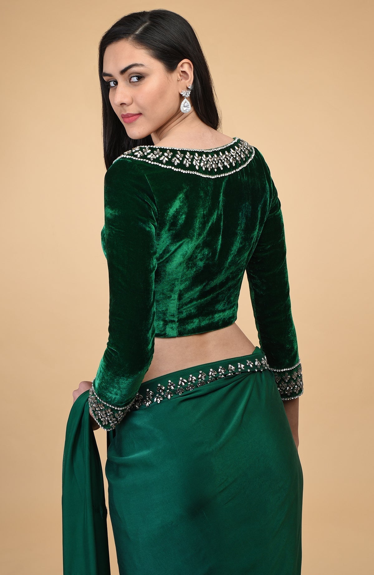 Emerald green velvet blouse with crystal embroidery, paired with a matching draped skirt.