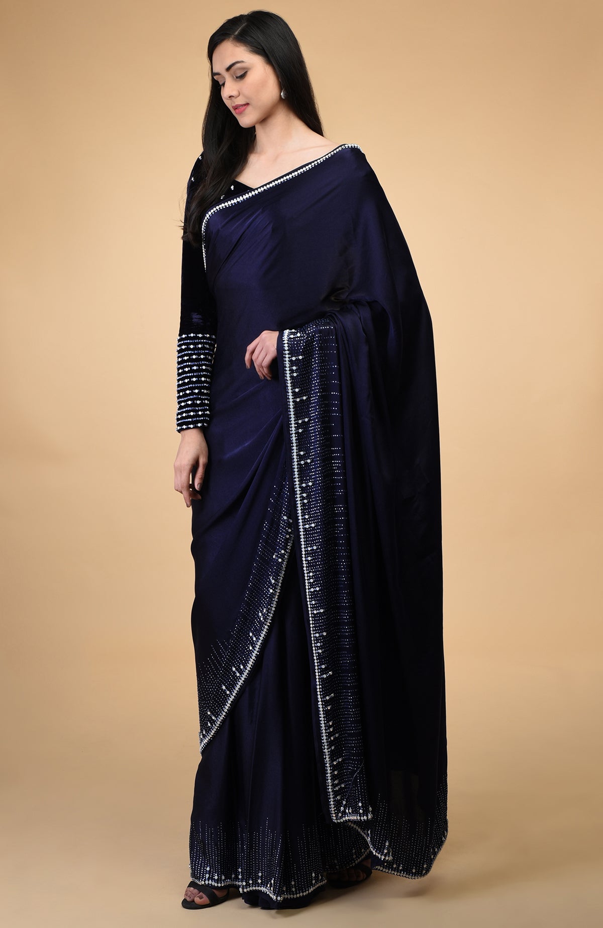A woman models a midnight blue crystal hand-embroidered blouse and matching saree.